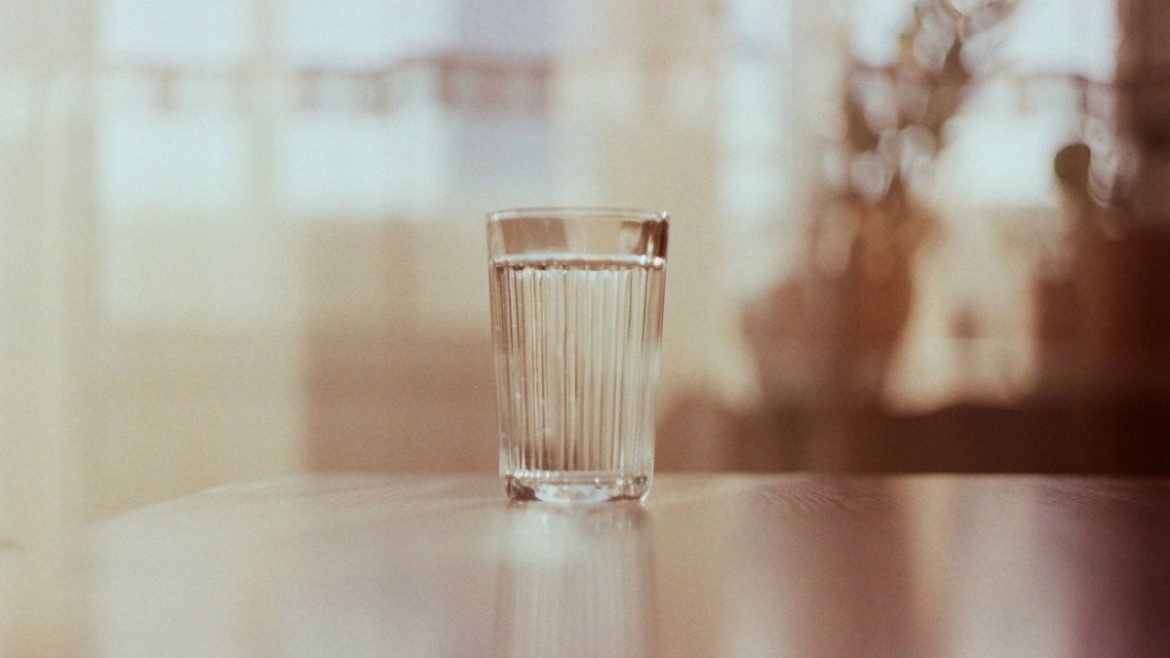 Склянка води на столі в теплому світлі