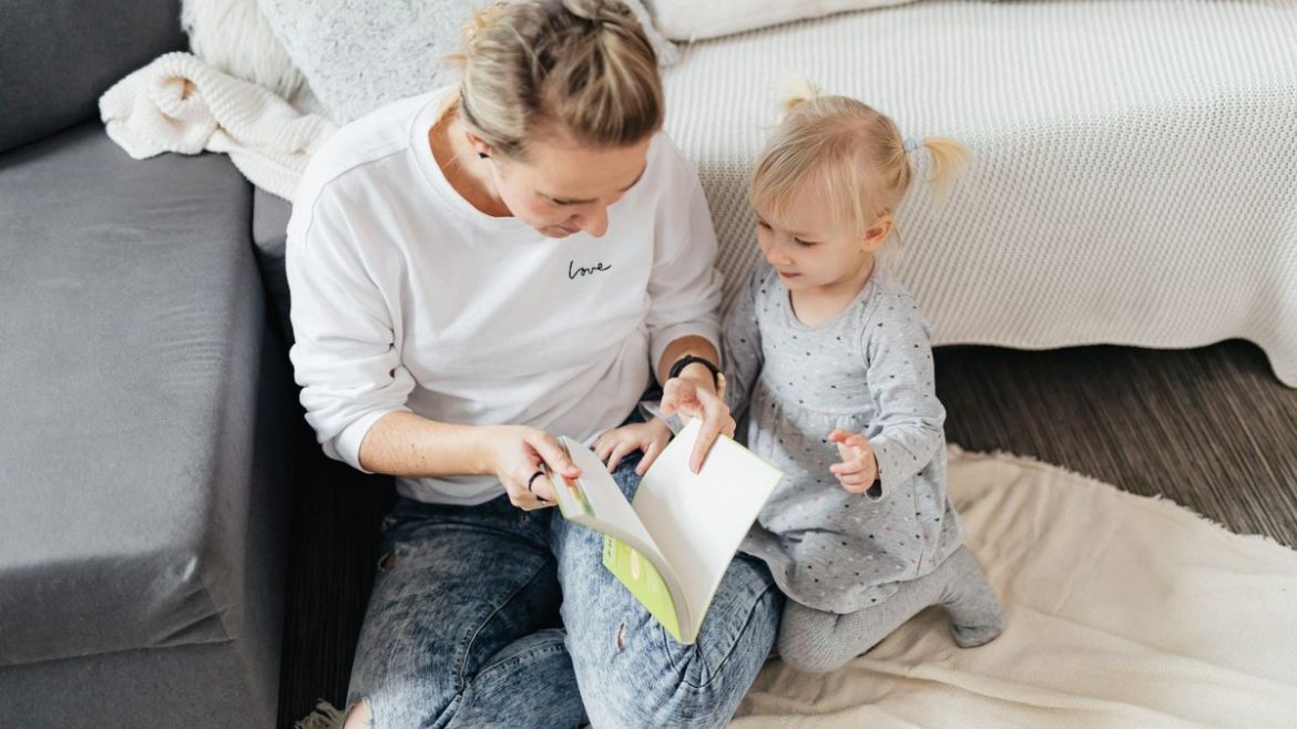 Мама читає книжку з малюком удома